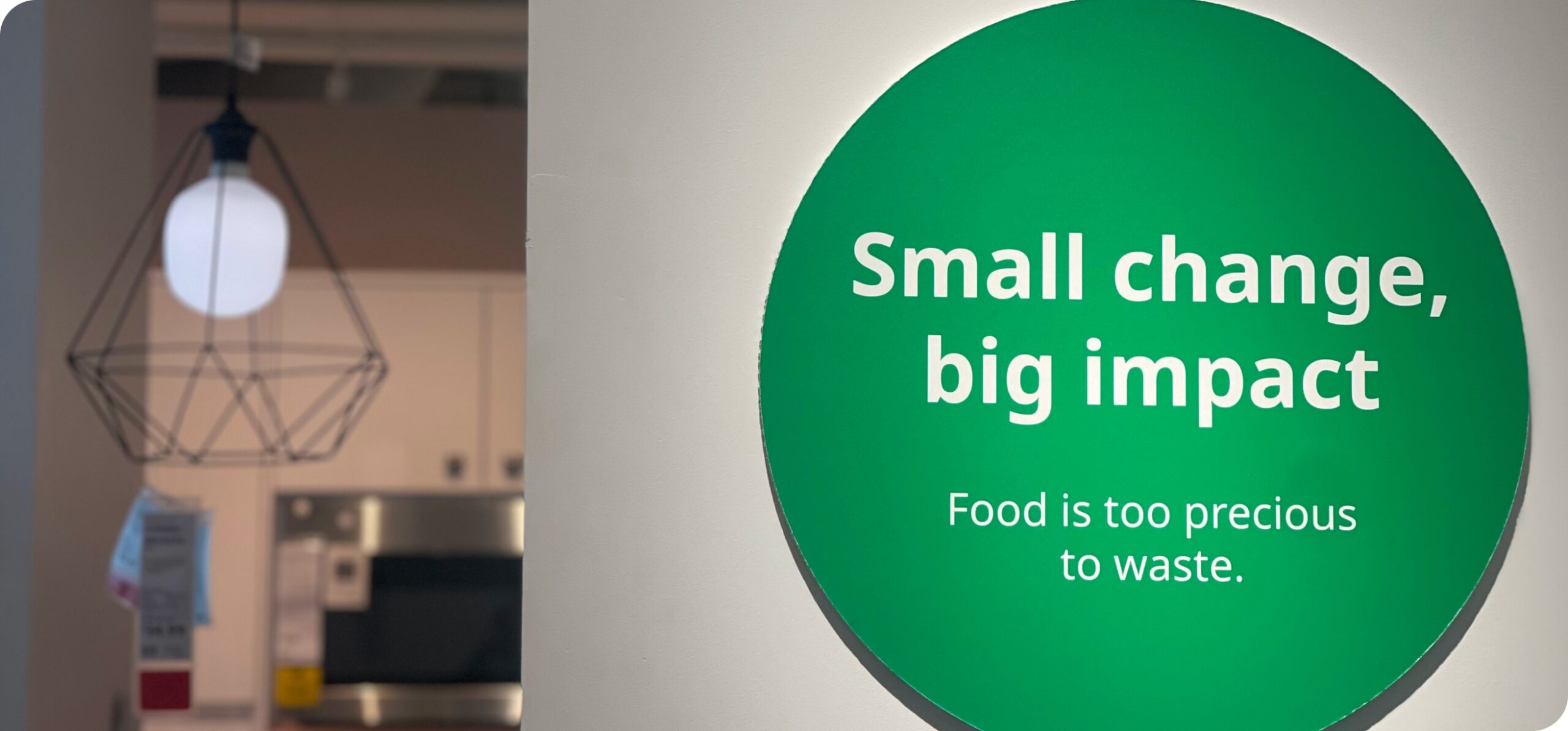 IKEA sustainability signage reading “Small change, big impact. Food is too precious to waste,” displayed inside the store.