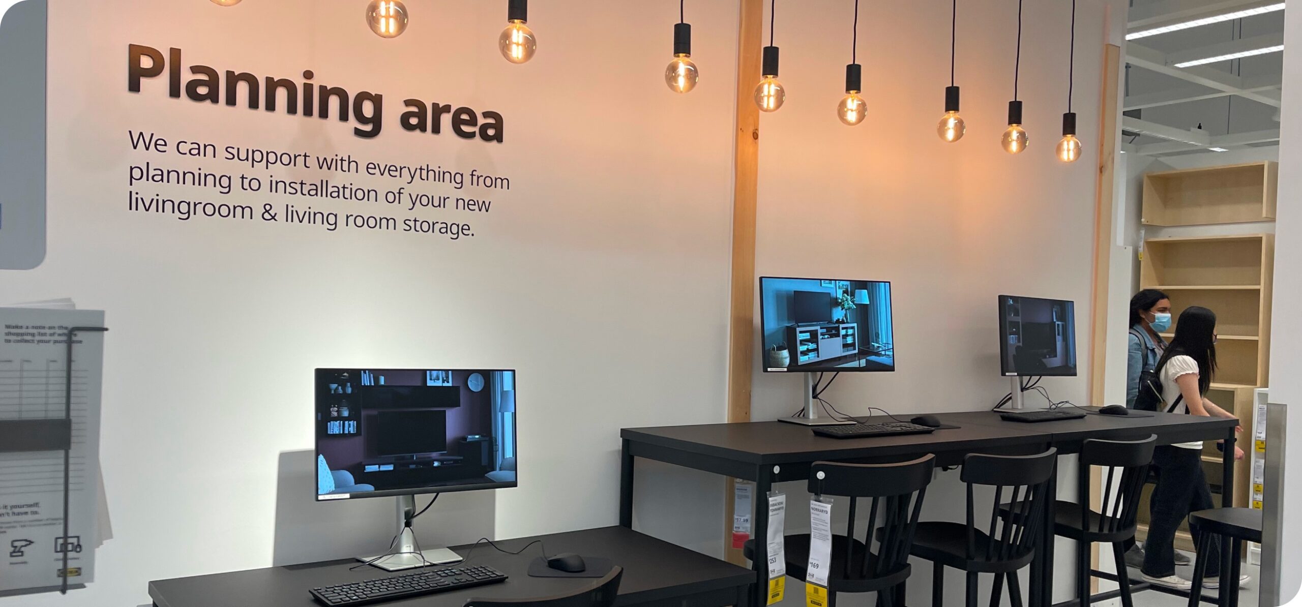 IKEA planning area with wall signage, computer stations, and lighting for customer workspace and design support.