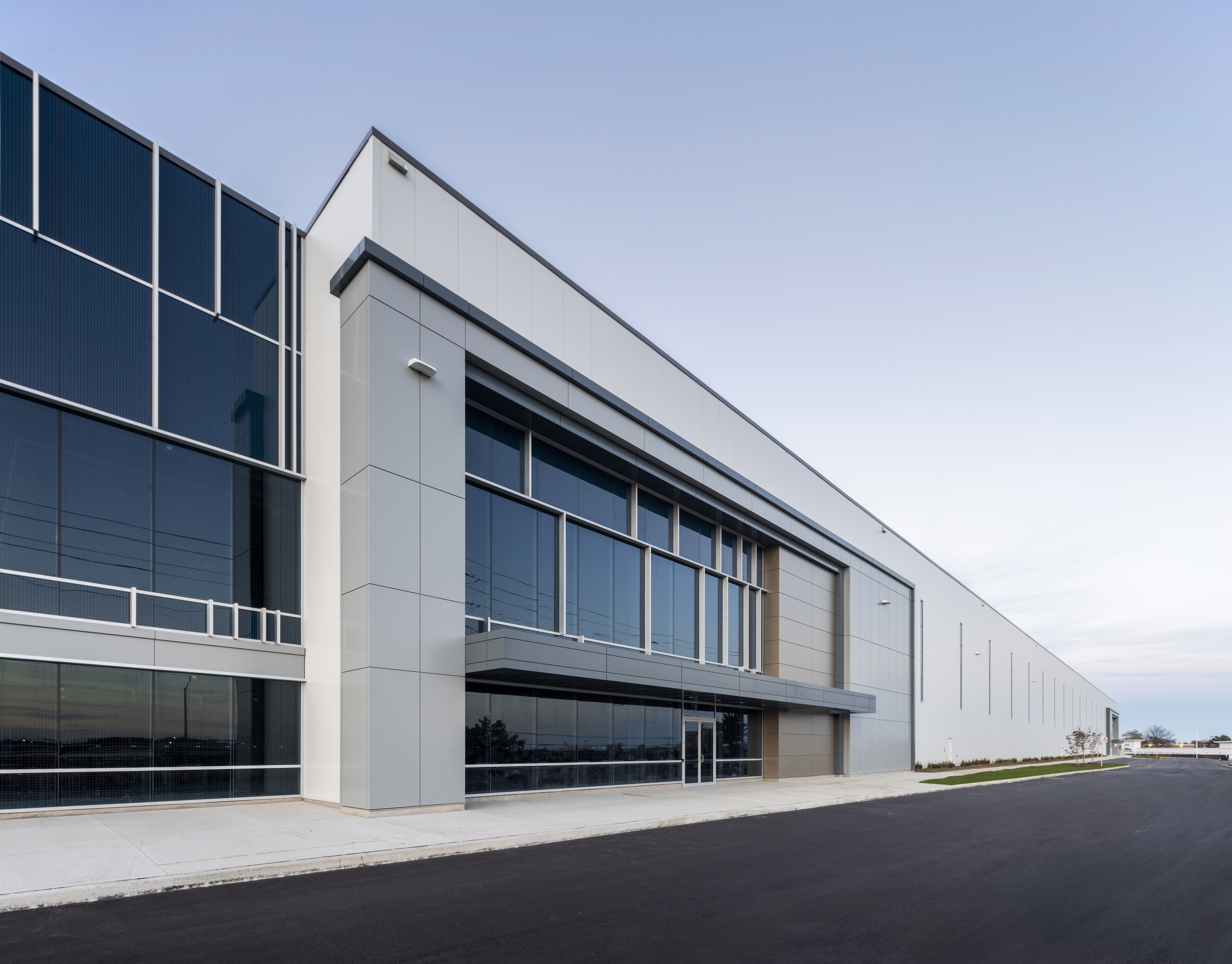 Side exterior view of the building at 6525 Mississauga Road North with continuous glazing and a paved access road.