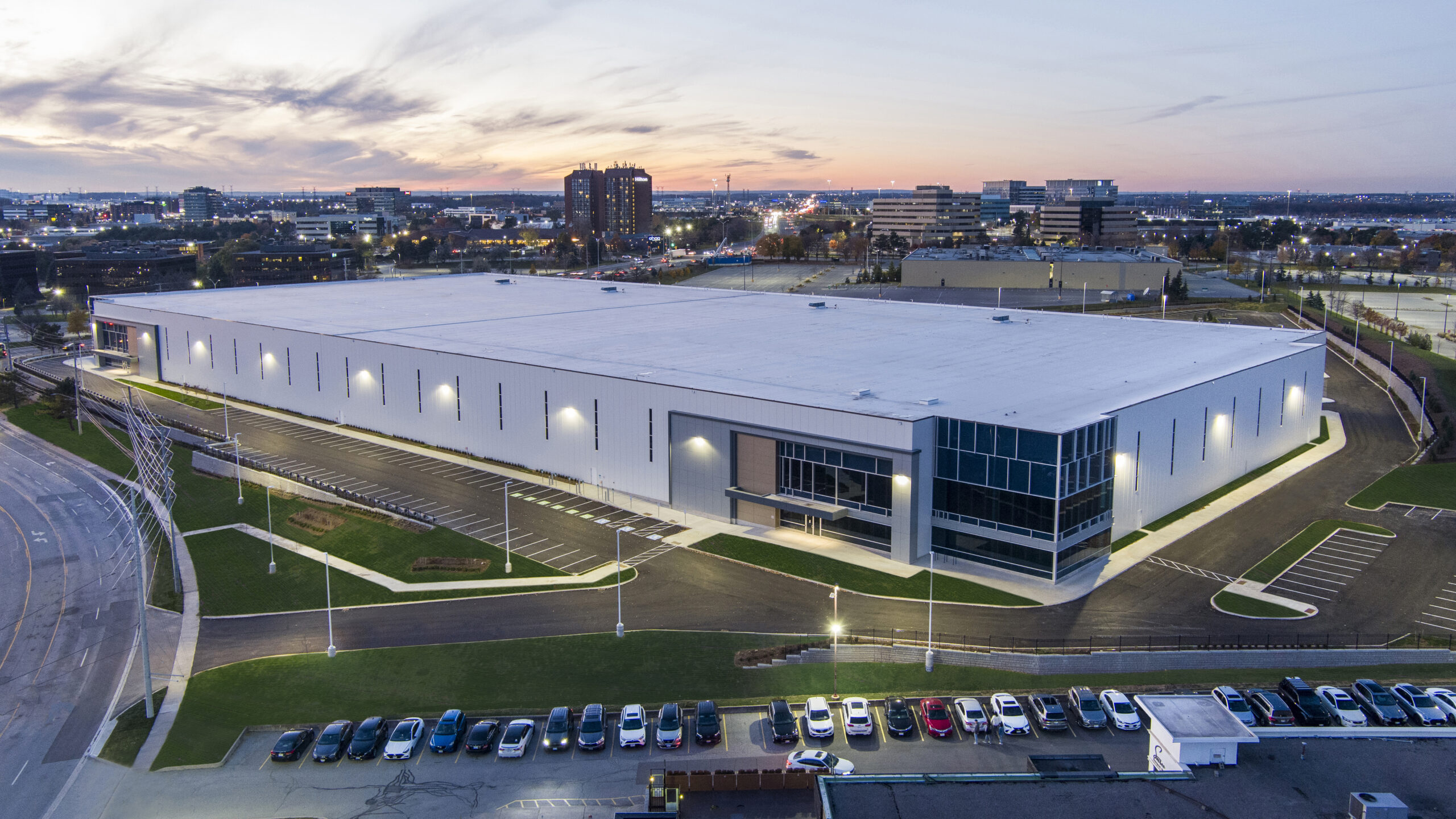 Aerial view of the industrial facility at 6525 Mississauga Road North with illuminated exterior lighting, parking areas, and surrounding roads.