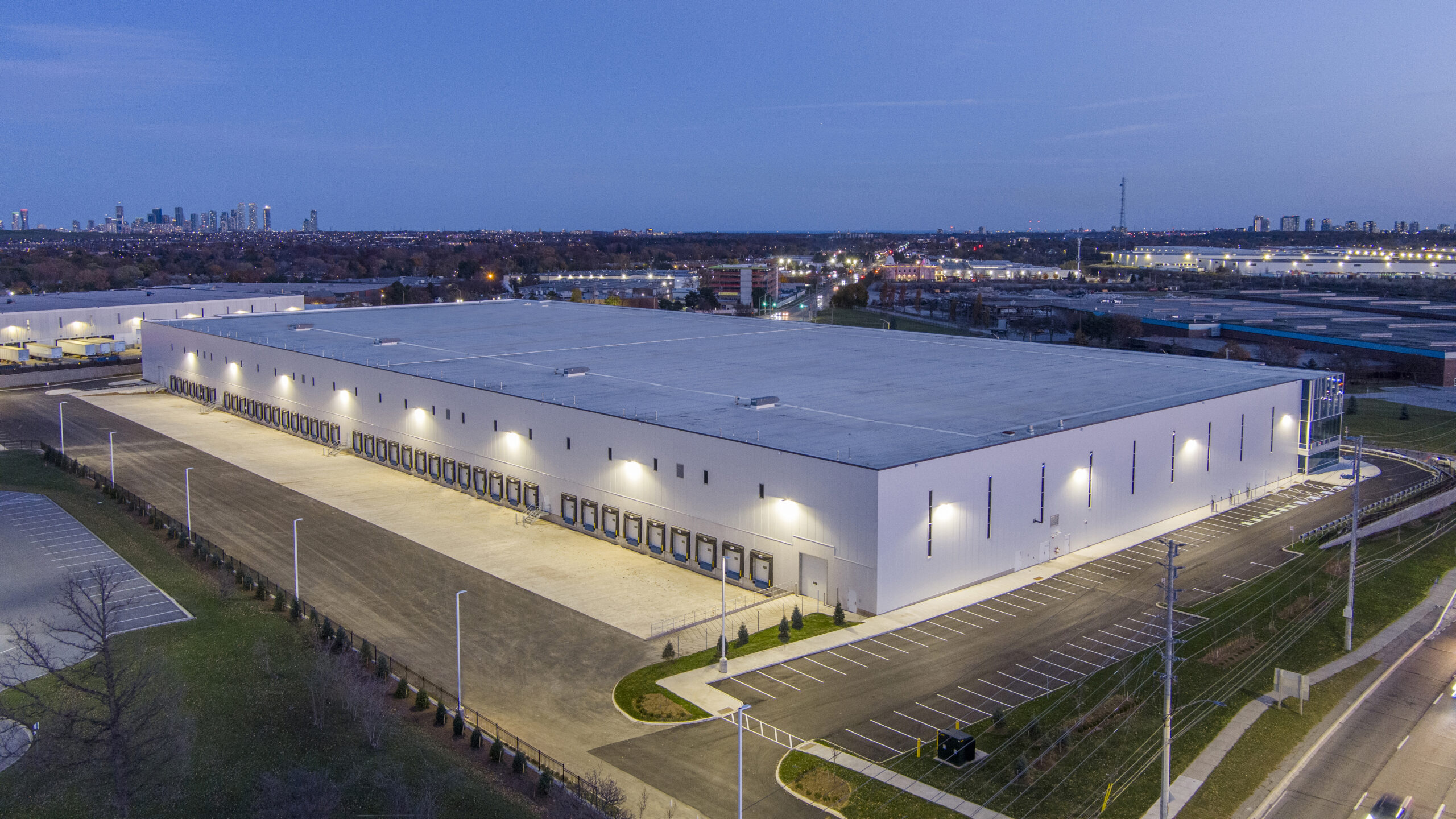 Nighttime aerial view of the building at 6525 Mississauga Road North showing illuminated perimeter lighting and loading areas.