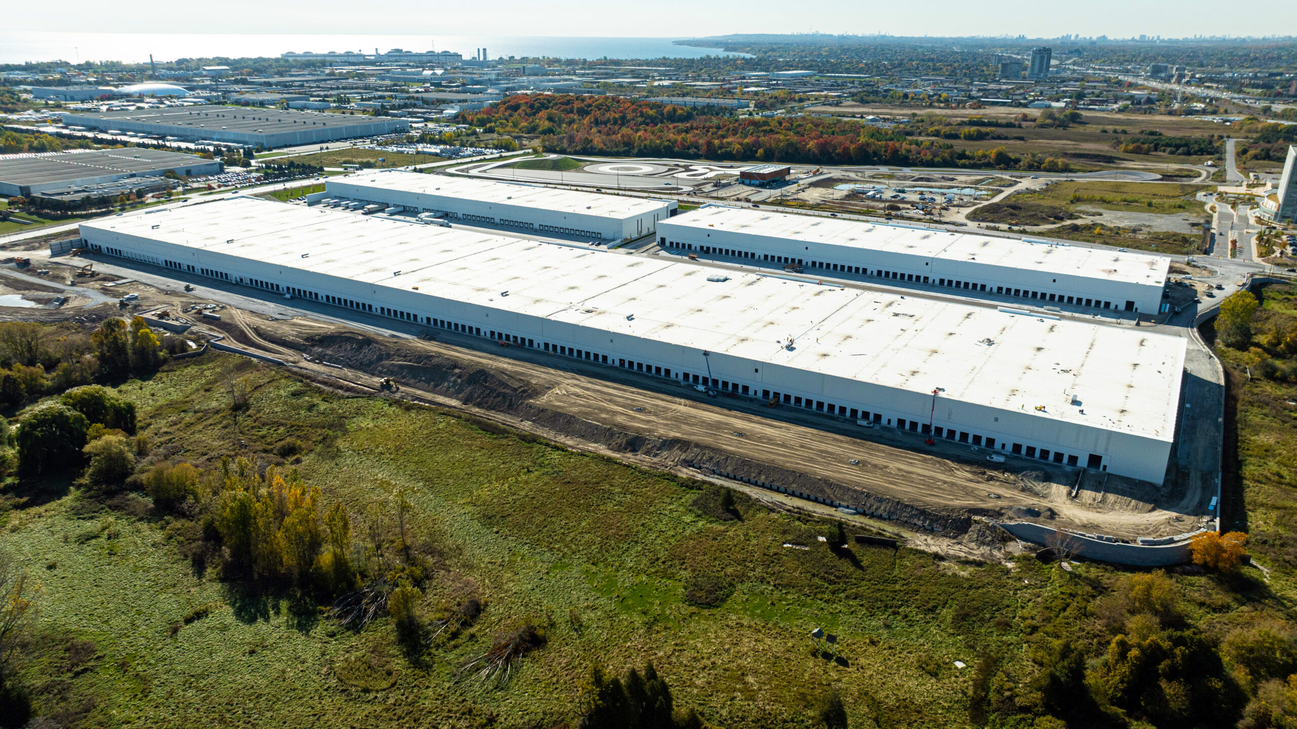 Aerial view of a long industrial building at Ajax Industrial on the Park bordered by green space and service areas.