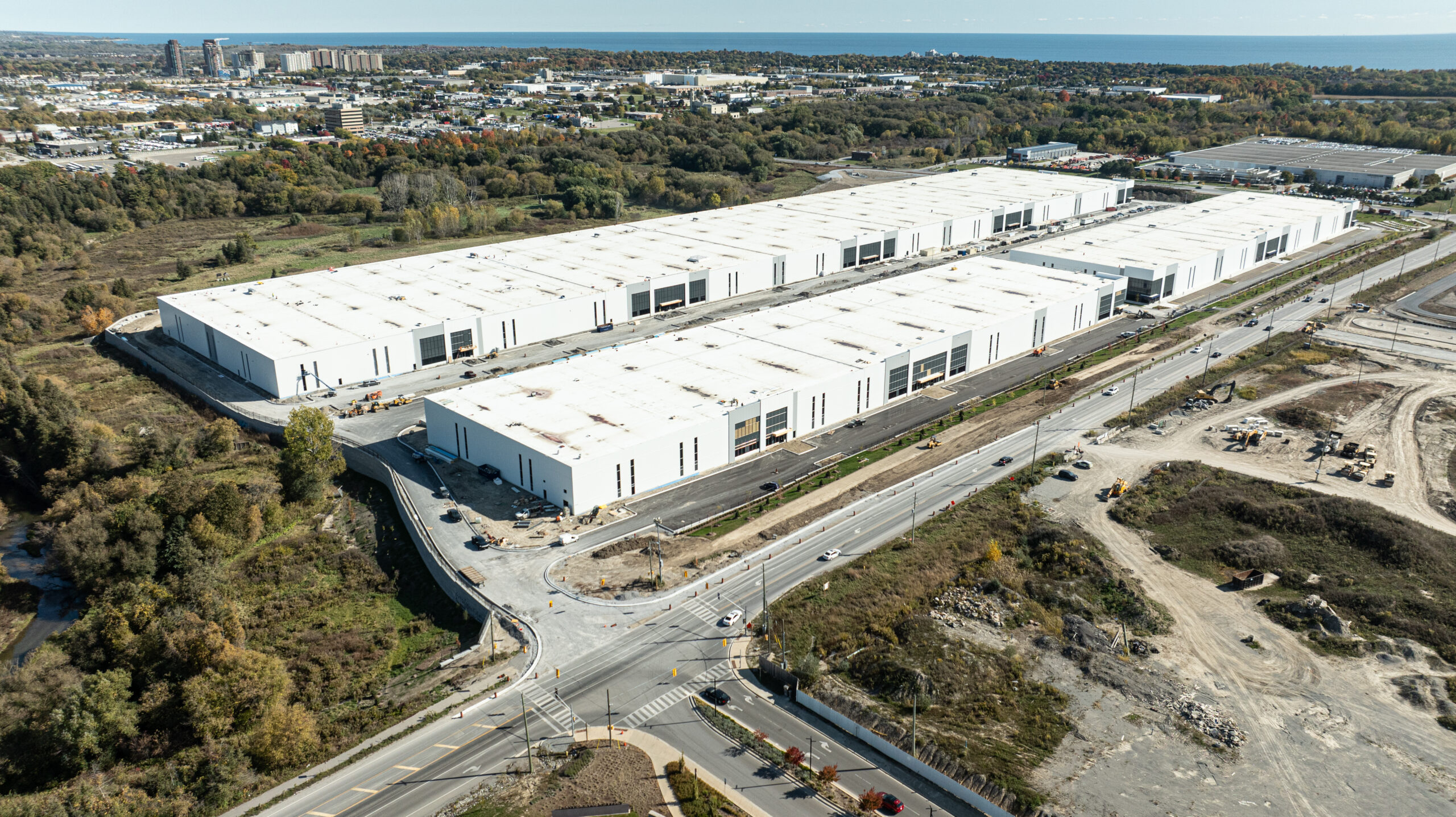 Wide aerial view of Ajax Industrial on the Park showing multiple warehouse buildings, internal roads, and nearby development.