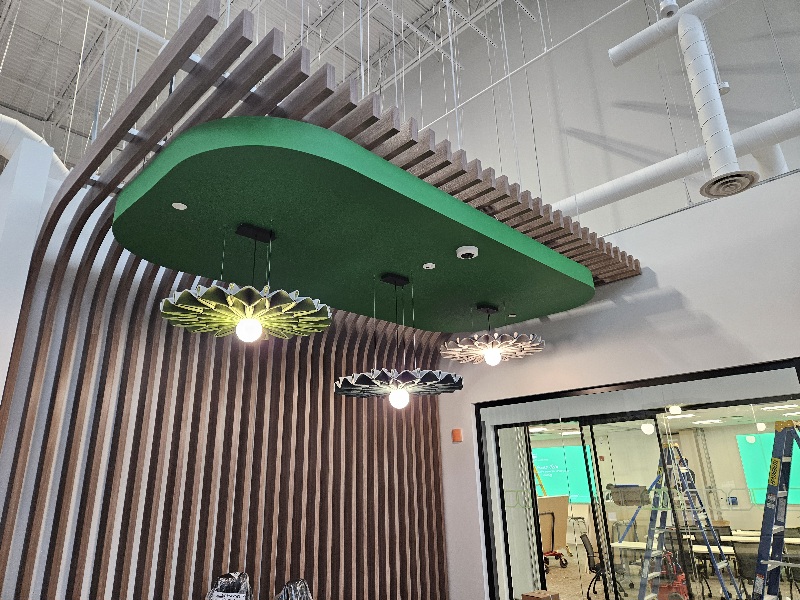 Custom suspended ceiling element with decorative LED pendant lighting and exposed ductwork at Schneider Electric’s Milton facility.