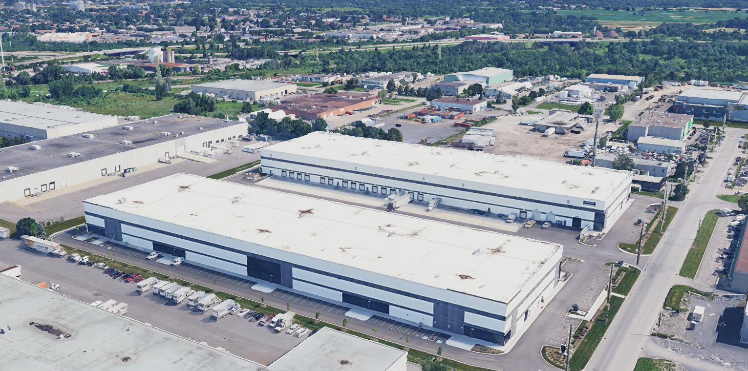 Aerial view of a large industrial warehouse building surrounded by roads and commercial properties.