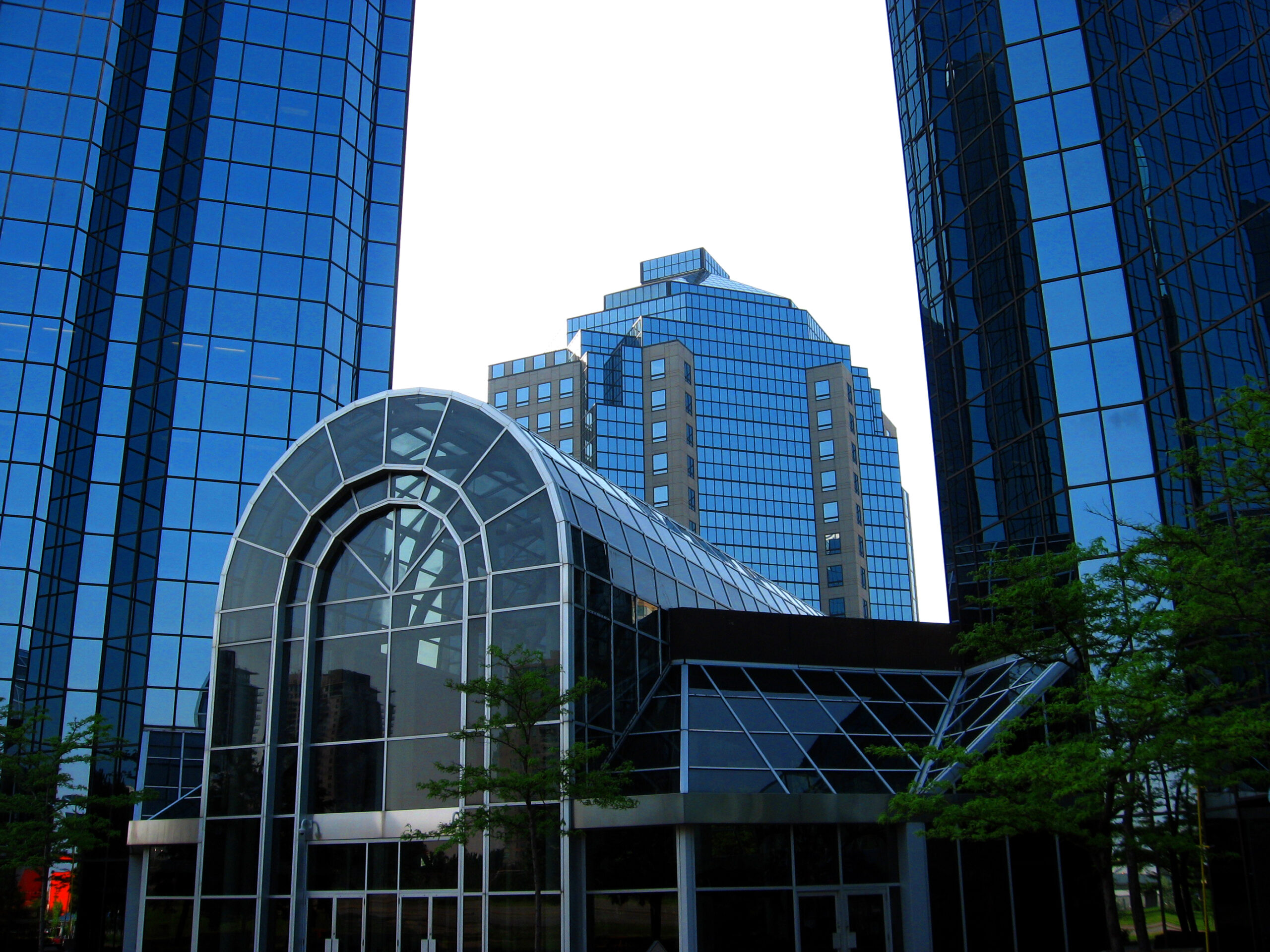 Main entrance to Consilium Place with an arched glass canopy and surrounding office towers.