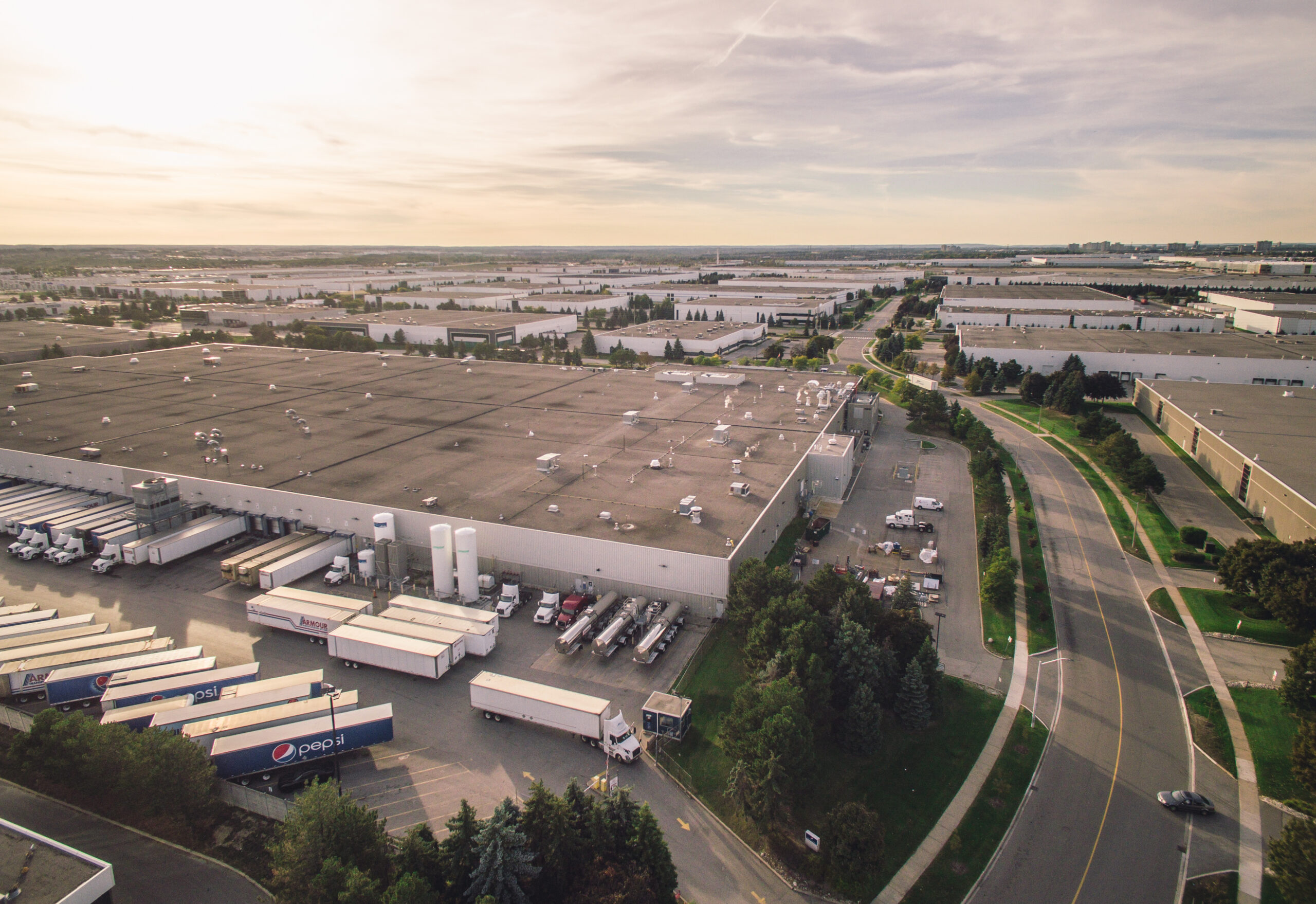 Aerial view of a PepsiCo distribution facility showing loading docks, trailer parking, service roads, and adjacent industrial buildings.