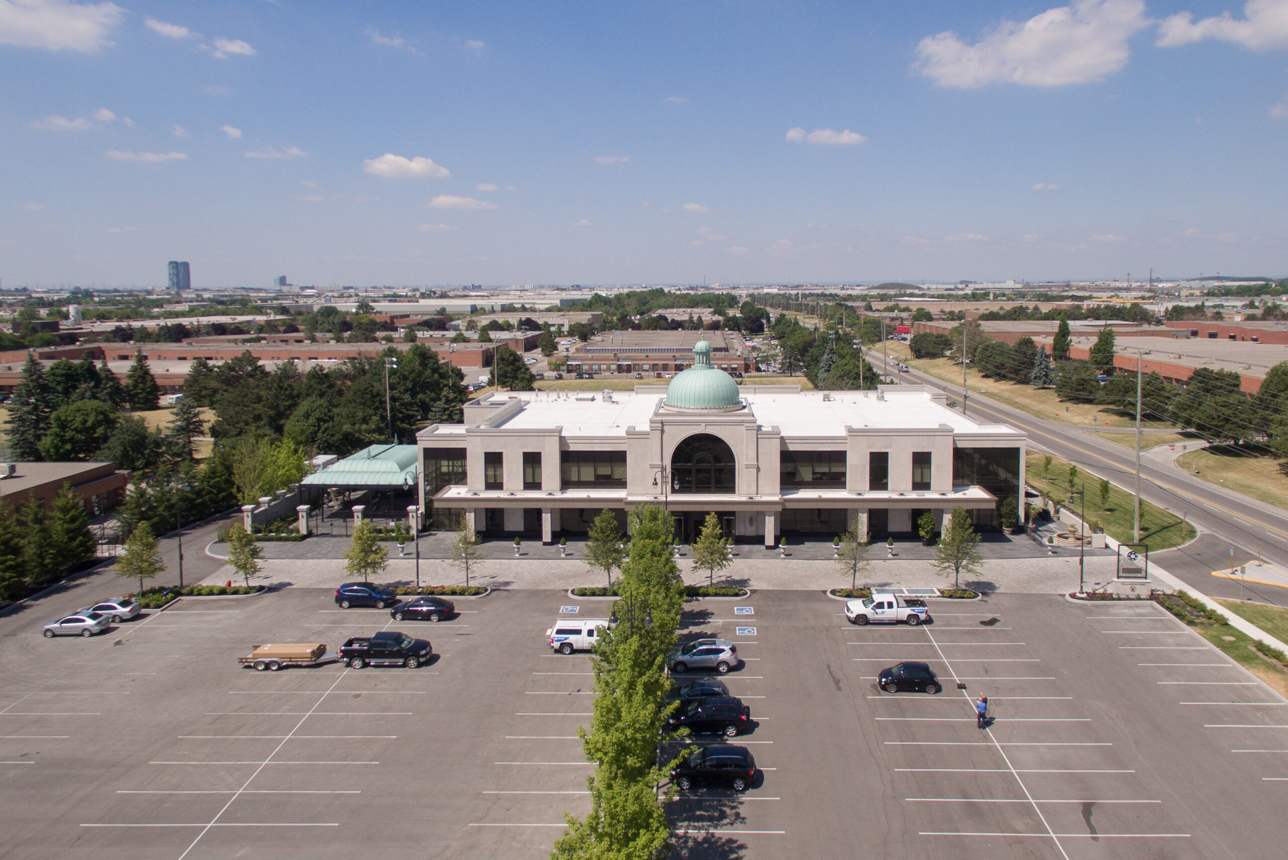 Aerial view of a large event venue with a central dome, surrounding parking, and nearby roadways.