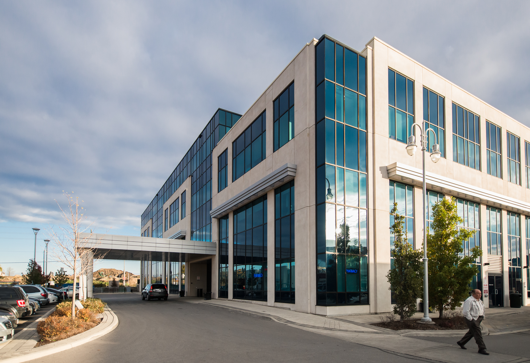 Exterior view of a modern medical office building with glass windows, an entrance canopy, and a driveway.