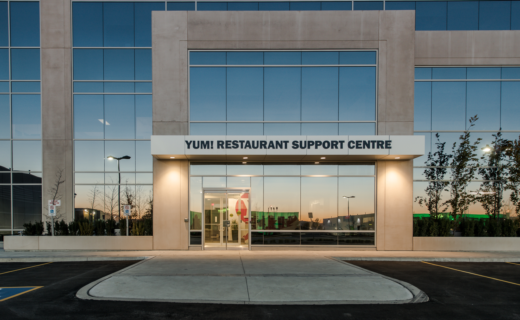 Main entrance of the YUM! Restaurant Support Centre with glass doors and signage above the entry.